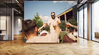 Sunny Joy. Friends gathering in outdoor cafe space, drinking beer and enjoying cheerful and relaxing vibes of summer picnic. Concept of summer, leisure, friendship, meeting, fun, relaxation Wall mural