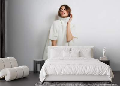 Tender. Portrait of beautiful brunette woman in comfortable soft longsleeve isolated on white studio background. Home comfort, emotions, facial expression, winter mood concept. Copyspace. Wall mural