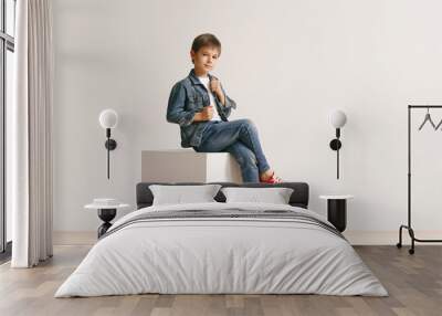 The portrait of cute little kid boy in stylish jeans clothes looking at camera against white studio wall. Kids fashion concept Wall mural