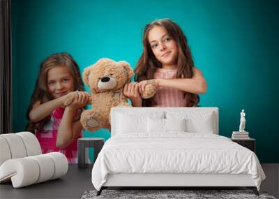 The two cute little girls on blue background with Teddy bear Wall mural