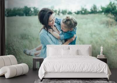 The young mother and daughter on green grass background  Wall mural