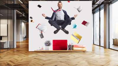 The young zen businessman relaxing at office in yoga pose lotus, while his work is doing. levitation concept Wall mural