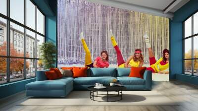 Three stylish young girls in colorful sportswear, bodysuits and leggings training, doing stretching and aerobics exercises. Concept of retro fitness, sport, 80s fashion, beauty, health Wall mural