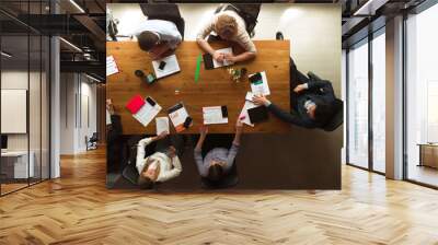 Top view of group of young people, co-workers during working process, meeting at office, indoors. Work, finance, tech and business concept. Loft style Wall mural