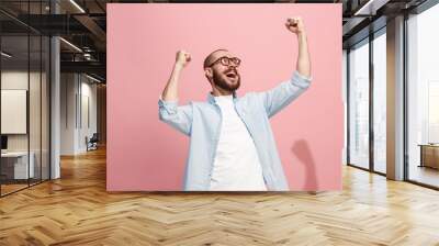 Winning success man happy ecstatic celebrating being a winner. Dynamic energetic image of male model Wall mural