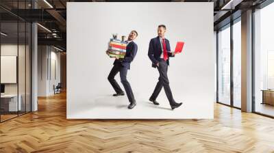 Young businessman in a suit juggling with office supplies in his office, isolated on white background. Conceptual collage with phone, folders. The business, office, work concept. Wall mural