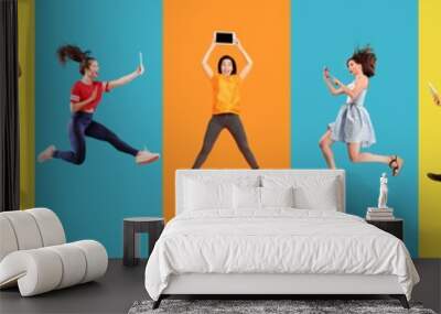 Young emotional people jumping high on multicolored background. Celebrating, winning men and women. Emotions, facial expression concept. Using devices, gadgets. Selfie, vlog. Collage made of 8 models. Wall mural