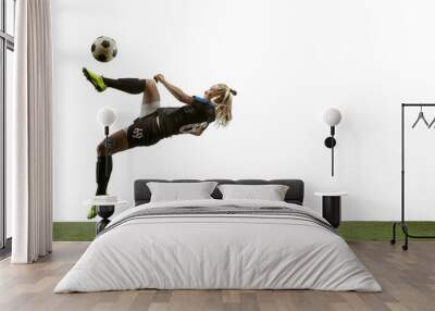 Young female soccer or football player with long hair in sportwear and boots kicking ball for the goal in jump on white background. Concept of healthy lifestyle, professional sport, motion, movement. Wall mural