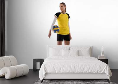 Young female volleyball player isolated on white studio background. Woman in sport's equipment and shoes or sneakers training and practicing. Wall mural