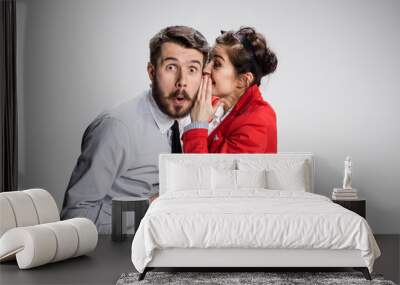 young man telling gossips to his woman colleague at the office Wall mural