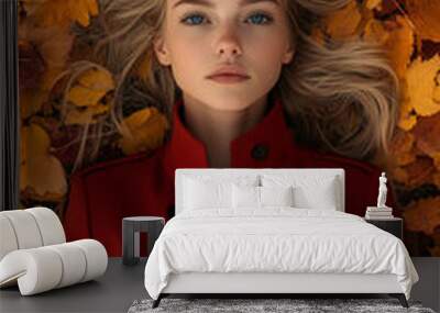 beautiful woman in red coat laying on top of autumn leaves Wall mural