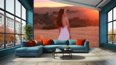 a Asian woman in white dress in a field in Tuscany, Italy under sunset  Wall mural