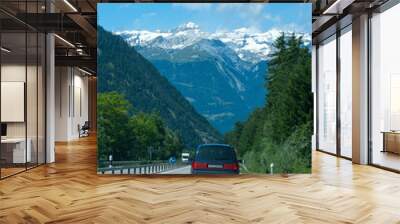 road with cars to snowy mountains horizon Wall mural