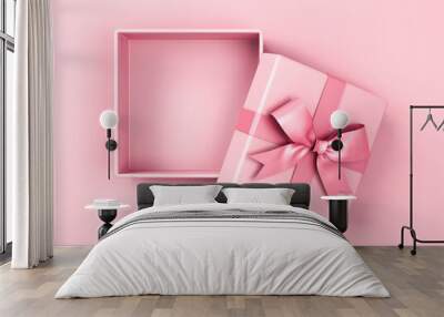 Blank pink pastel color present box or open gift box with pink ribbon and bow isolated on pink pastel color background with shadow top view 3D rendering Wall mural