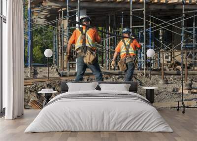 Two construction workers carrying metal rods on their shoulder Wall mural