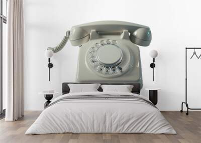 A black rotary phone sits alone on a white background, a relic of a bygone era of communication technology Wall mural