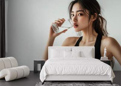 A beautiful Japanese woman is drinking water from the glass. Portrait. close up view Wall mural