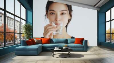 A beautiful Japanese woman is drinking water from the glass. Portrait. close up view Wall mural