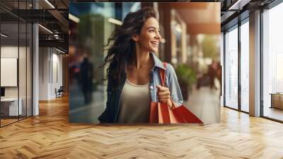 A fashionable, young happy girl walks in with her purchases from a shopping spree. Discounts and promotions in stores Wall mural