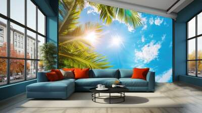 A sunny tropical background with palm trees and a blue sky. A view from below Wall mural