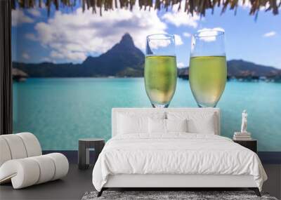 Two glasses of champagne overlooking turquoise water in Bora Bora during honeymoon Wall mural