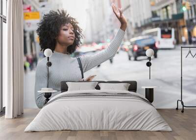 Woman hailing taxi cab or ride share car service in New York Wall mural