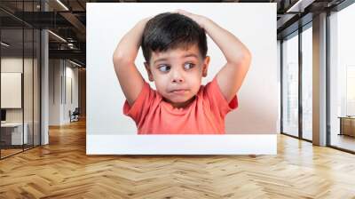 Cute boy in orange t-shirt on the white background Wall mural