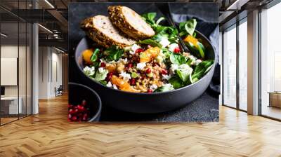 Buckwheat salad with lamb's lettuce, pomegranat seeds, goat cheese, mandarine and spring onion, Served with whole grain baguette and red wine. Black table and black background. Wall mural