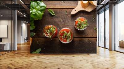 Vegan tomato gazpacho with fresh herbs. Served in glass jars. Rustic, wooden background. Wall mural