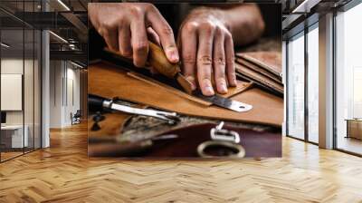 Close up of a shoemaker or artisan worker hands. Leather craft tools on old wood table. Leather craft workshop. Wall mural