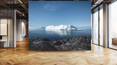 Arctic nature landscape with icebergs in Greenland icefjord with midnight sun sunset sunrise in the horizon. Early morning summer alpenglow during midnight season. Ilulissat, West Greenland. Wall mural