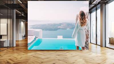 Woman having breakfast by the pool in santorini, greece Wall mural