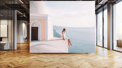 woman sitting on rooftop in Santorini Wall mural