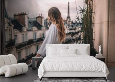 Young woman with blonde hair on Paris balcony in front of Eiffel Tower Wall mural