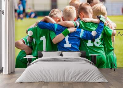 Happy boys play team sport. Kids smiling in school sports team. Children together in huddle. Cheerful children boys players of school soccer team Wall mural