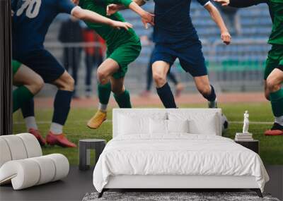 Soccer football player dribbling a ball and kick a ball during match in the stadium. Footballers in action on the tournament game. Adult football competition Wall mural