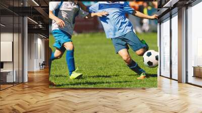 Youth soccer football league. Young boys in white and blue soccer jerseys play tournament match during youth football tournament Wall mural