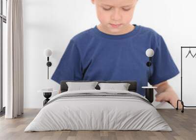 6-7 years old boy sitting with book isolated on white Wall mural