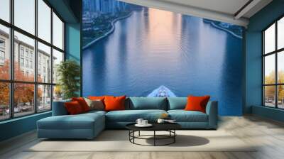 Luxury yacht cruising through a modern city at sunrise Wall mural