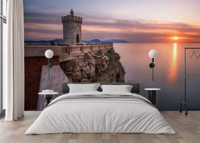 Sunset over the sea in Piombino. Small lighthouse, landmark in Tuscany, Italy. Wall mural