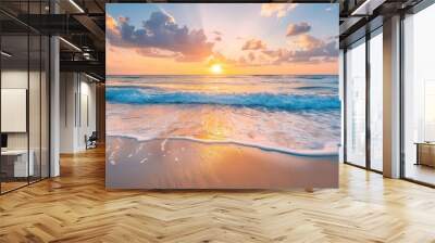 A beautiful sunrise over a sandy beach with waves gently crashing and clouds scattered across the sky Wall mural