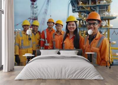 A diverse group of smiling workers in hi-vis gear pose together on an oil rig platform Wall mural