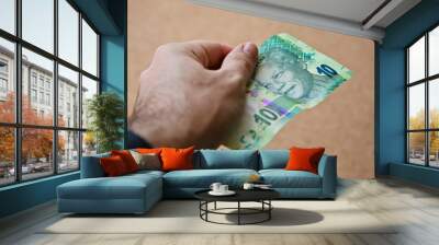 A hand holding South African money. RSA economy concept image.  Wall mural