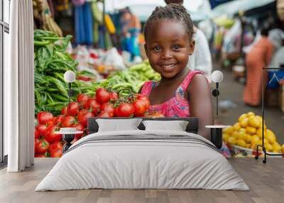 A joyful child holds a basket of fresh tomatoes at a vibrant market filled with various vegetables and fruits. Wall mural