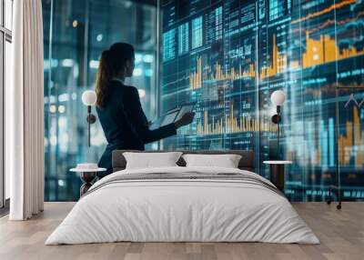 A professional woman analyzes data on a digital screen in a modern office setting. Wall mural