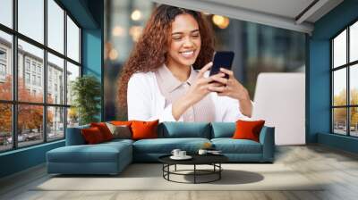 Im due for a social media break. Shot of a young woman using a phone and laptop while working at a cafe. Wall mural