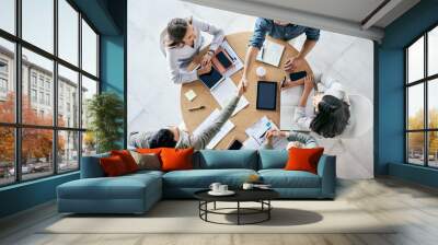 Meeting, handshake and overhead with a business team sitting around a table in the office at work. Partnership, thank you and welcome with male colleagues shaking hands in agreement of a b2b deal Wall mural