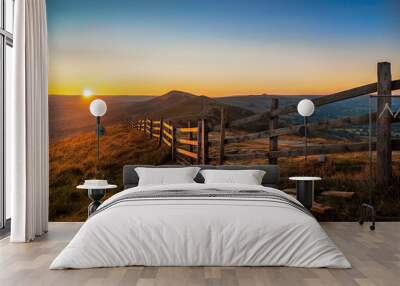 Stunning Mam Tor Peak District early morning dawn sunrise with long fence and beautiful golden hour orange light sun on the horizon of Hope Valley Castleton countryside landscape Wall mural