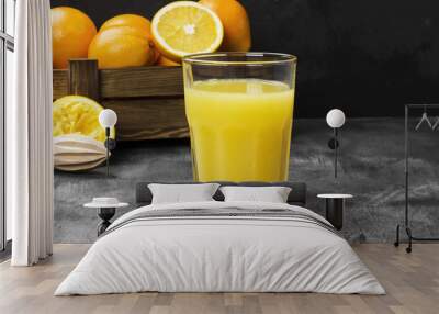 Oranges and fresh orange juice on a black background Wall mural