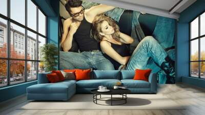 Sexy man and woman dressed in jeans doing a fashion photo shoot Wall mural